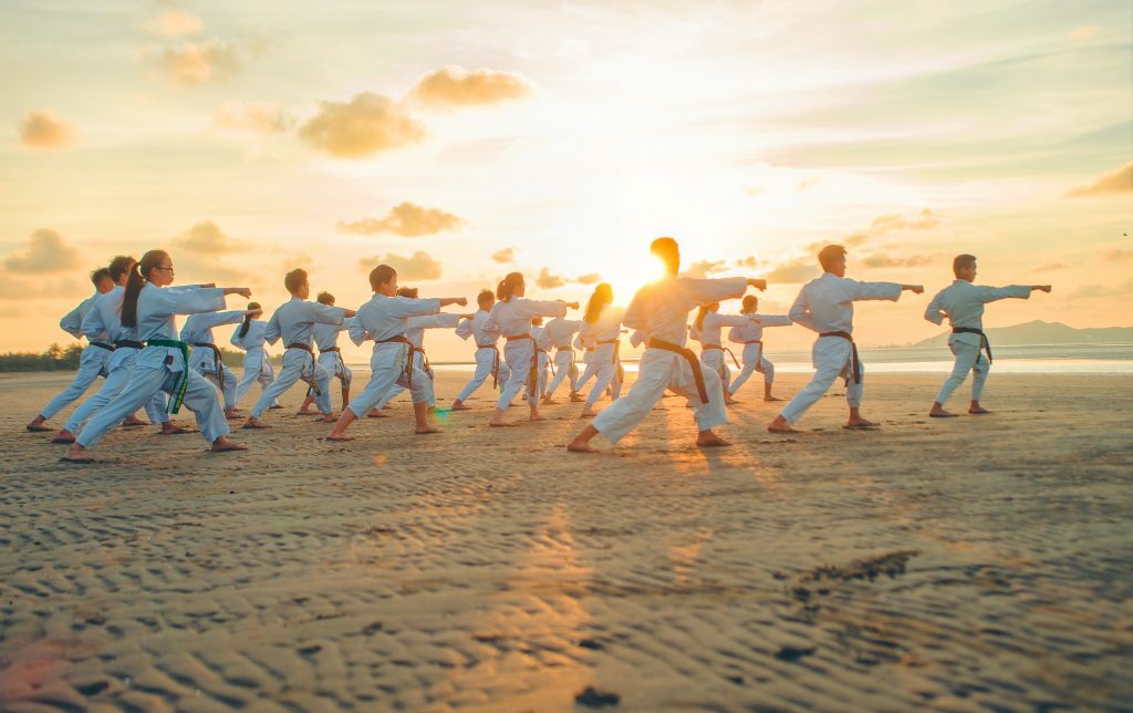 Zdjęcie pokazujące grupę dzieci ćwiczącą karate. To dyscyplina sportu pomagająca w koncentracji i planowaniu ruchów. Może być pomocna także w terapii ADHD