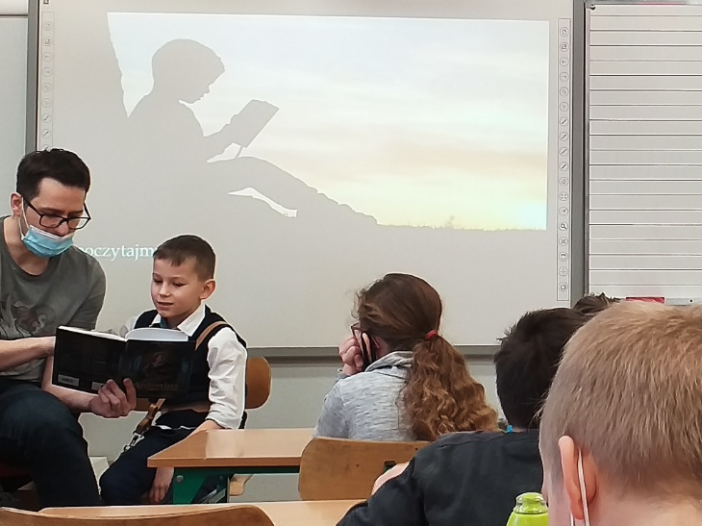 Antoni z tatą podczas spotkania autorskiego w szkole. Wspólne czytanie bajki "Antonius i magiczne stworzenia"